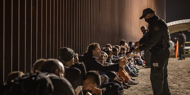 A CBP agent and migrants