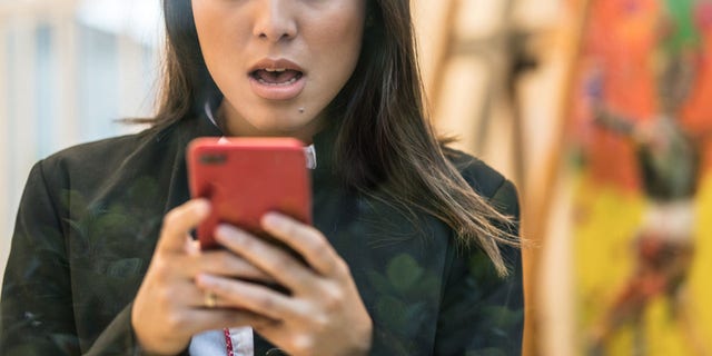 Business Woman worried about the news on her mobile phone