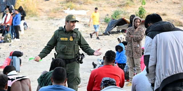 A U.S. Border Patrol agent talks with asylum-seekers