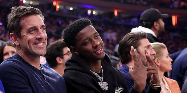 Sauce Gardner and Aaron Rodgers sit courtside