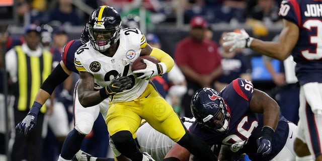 Le'Veon Bell runs with the football during a game