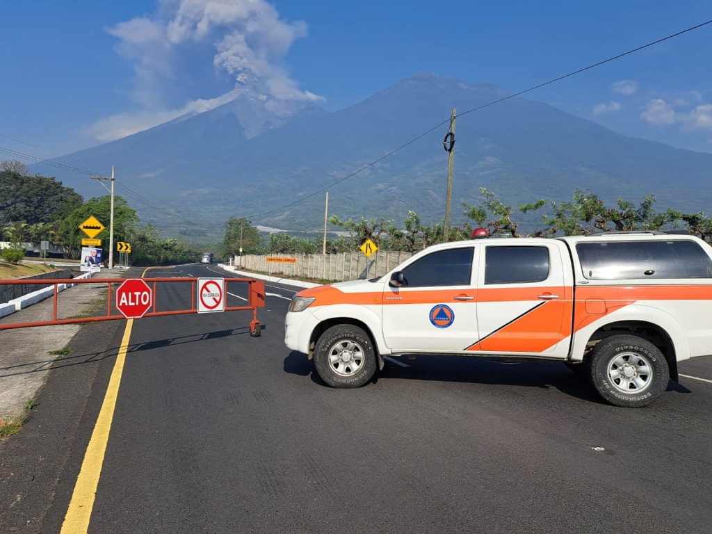 A vehicle of the Guatemala's disaster management agency (CONRED) blocks a road as the Fuego volcano spews a column of steam during an increase of its activity, in Alotenango, Guatemala on May 4, 2023.  