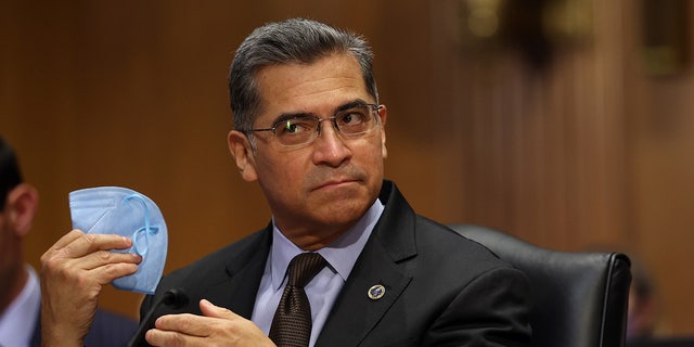 Xavier Becerra holds mask at hearing