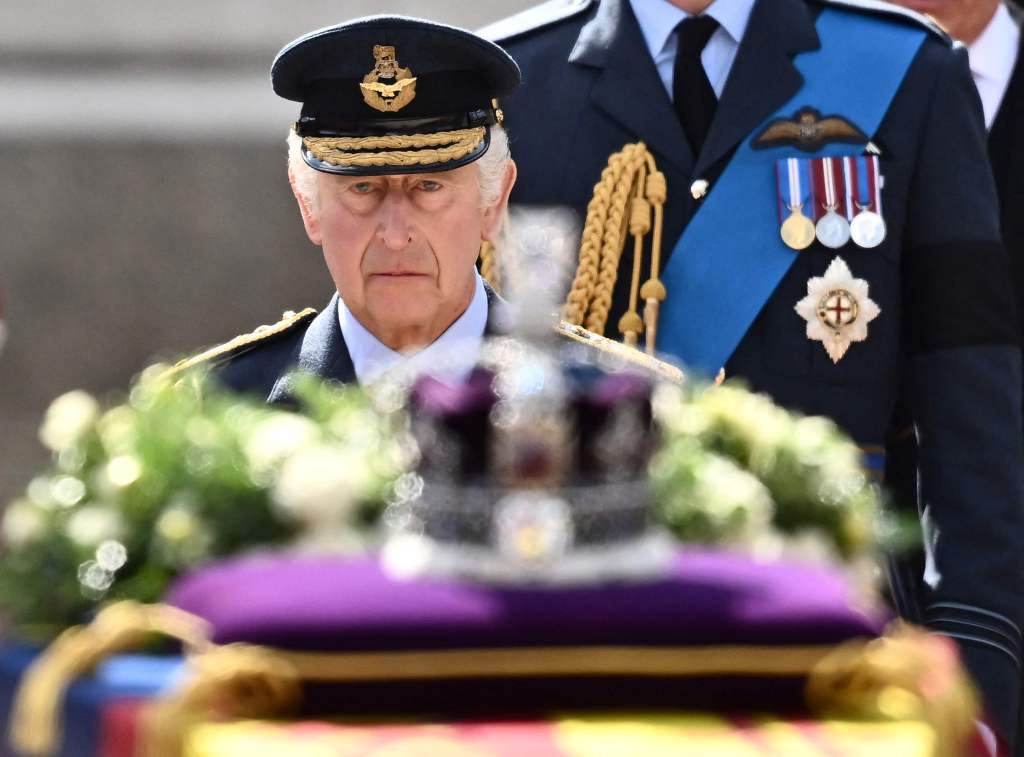 King Charles III walks behind the coffin of Queen Elizabeth II, adorned with a Royal Standard and the Imperial State Crown, during a procession from Buckingham Palace to the Palace of Westminster, in London. 