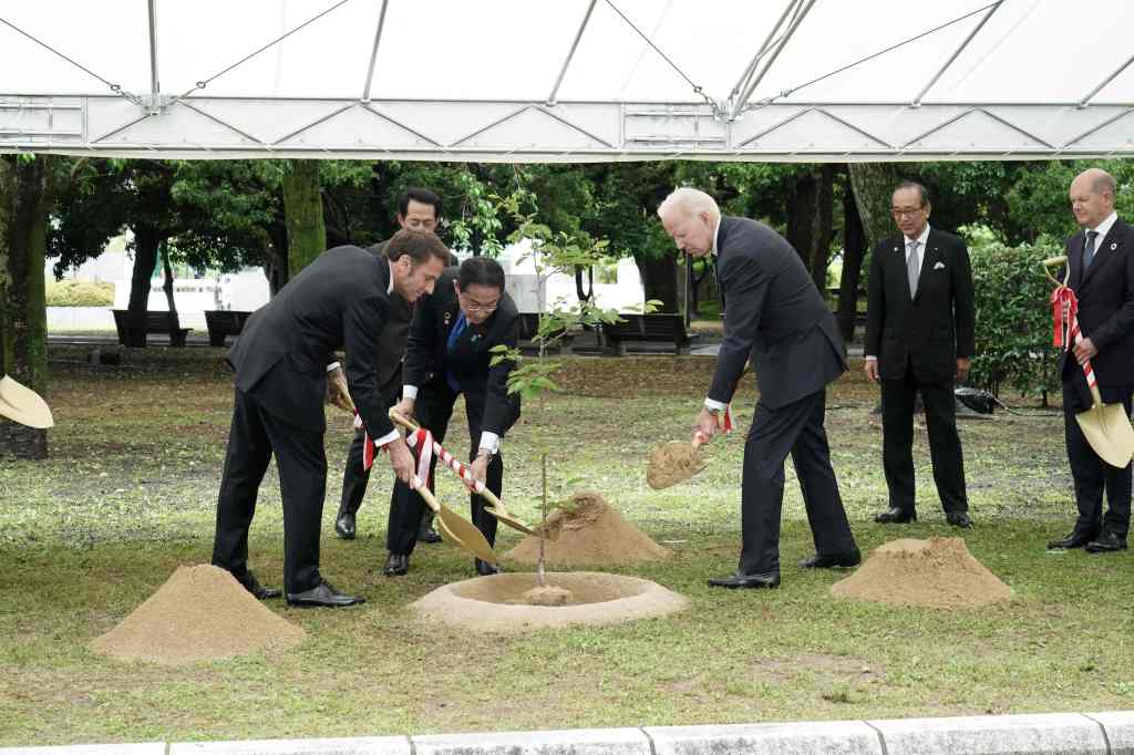 France's President Emmanuel Macron, Japan's Prime Minister Fumio Kishida, and President Joe Biden take part in a tree-planting ceremony during a visit to the Peace Memorial Park as part of the G7 Leaders' Summit in Hiroshima on May 19, 2023. 