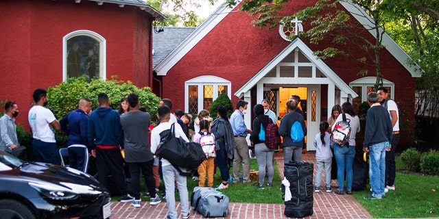 Migrants standing outside of a church