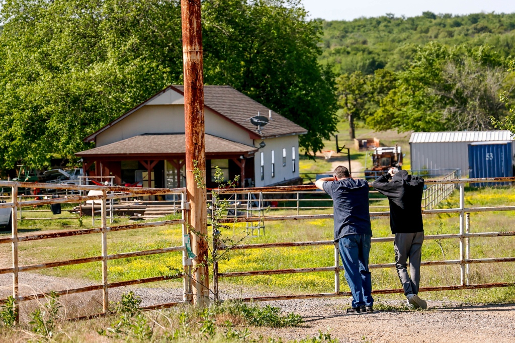 Two relatives of Ivy Webster, who was found dead Monday, are seen visiting the site where Ivy's body was found in Henryetta, Okla., on May 2, 2023. 