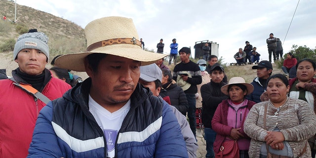 Several family members wait outside gold mine