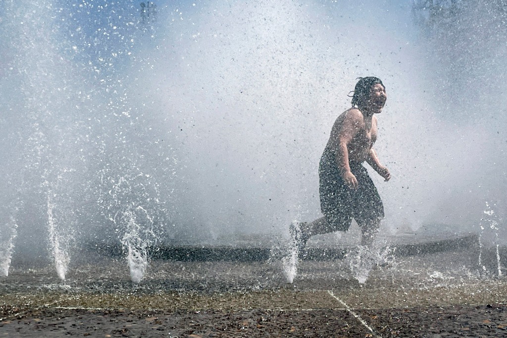 A child plays in a fountain to cool off in downtown Portland, Ore., as temperatures in the area are expected to hover around 94 F throughout the weekend. 