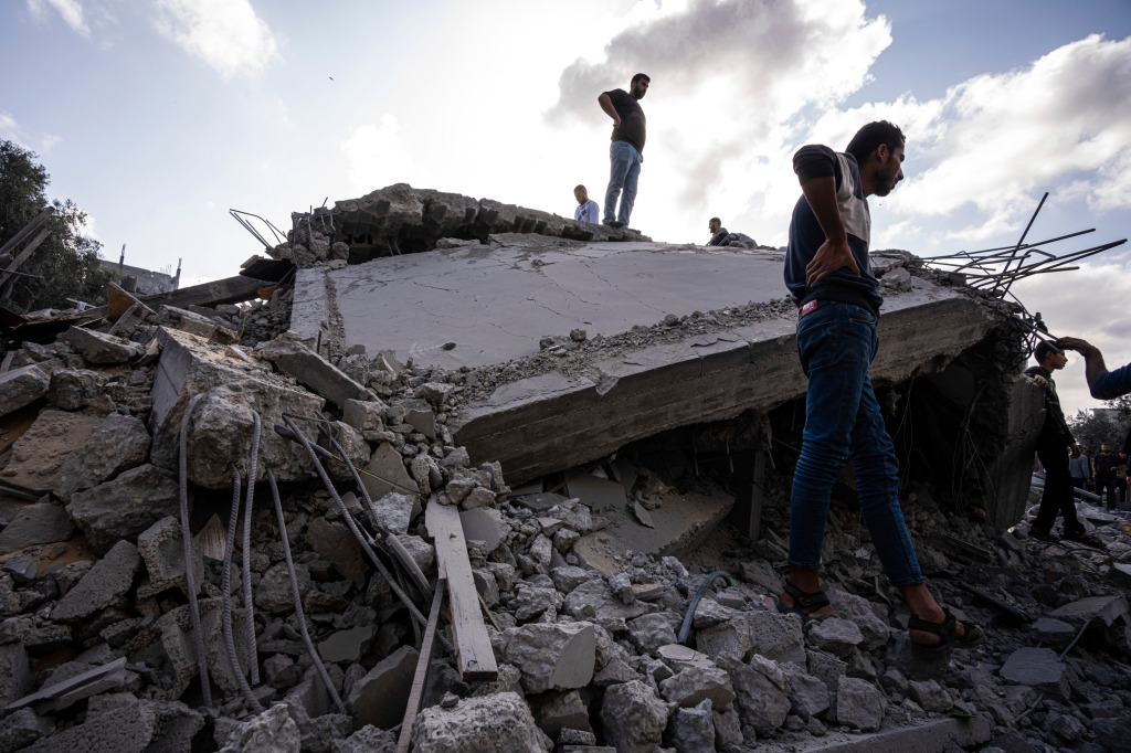 Palestinians inspect the rubble at the site of an airstrike that the Israeli military said targeted the house of an Islamic Jihad member.