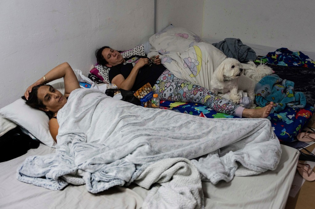 Israelis rest in the bomb shelter of an apartment building to stay safe from rockets fired from Gaza Strip toward Israel.