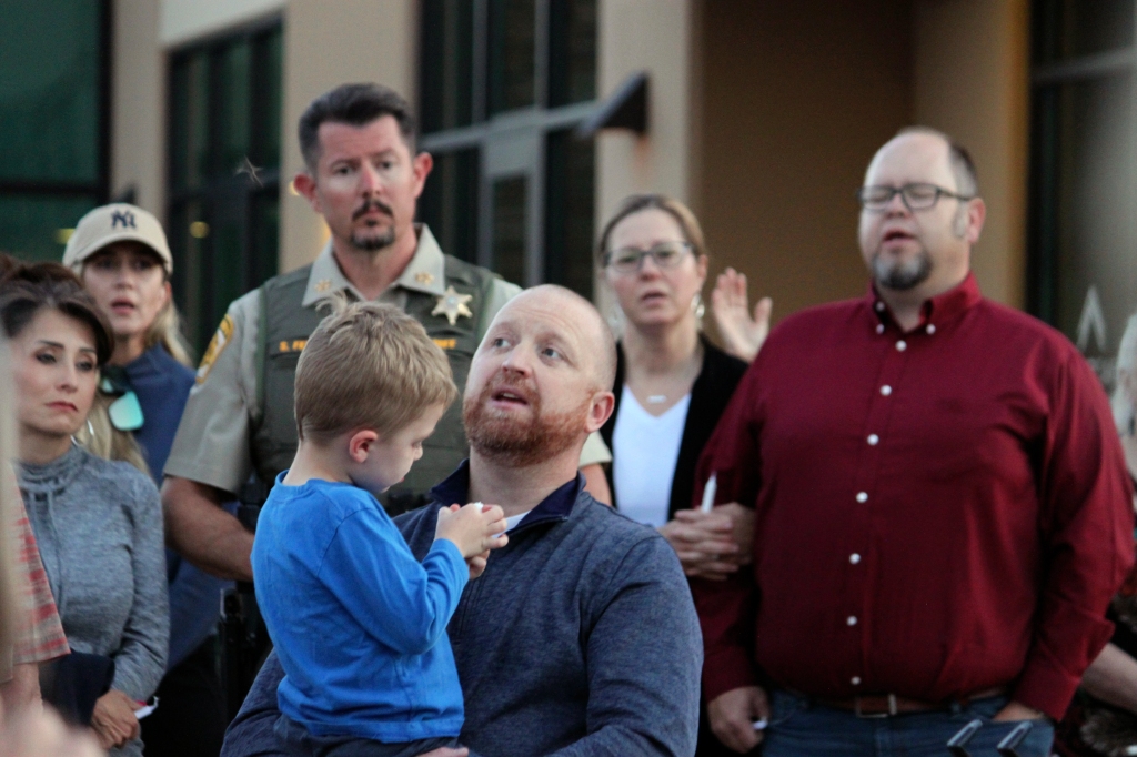 Pastor Matt Mizell, center, leads a prayer vigil as Farmington Mayor Nate Duckett, right, and dozens of community members gather following a deadly shooting in Farmington, N.M., on May 15, 2023. 