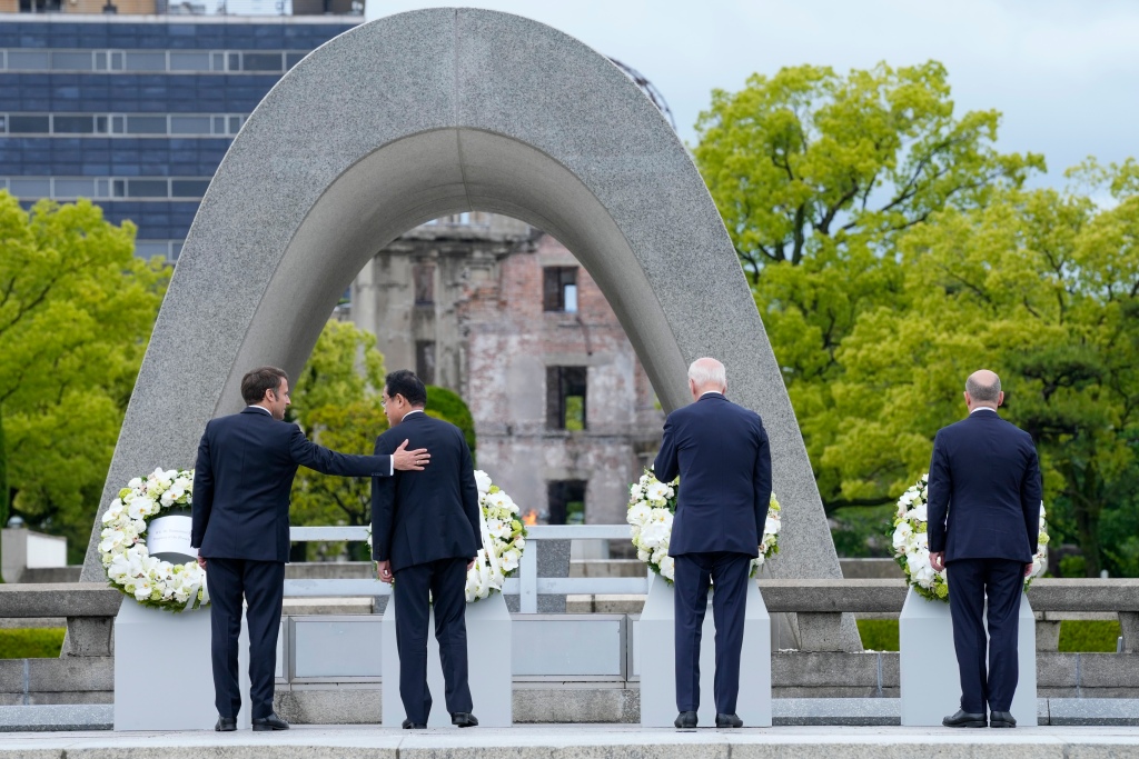 President Emmanuel Macron, left, of France gestures to Prime Minister Fumio Kishida of Japan after laying a wreath at the Hiroshima Peace Memorial Park with U.S. President Joe Biden and Chancellor Olaf Scholz, right, of Germany in Hiroshima, Japan, on May 19, 2023, during the G7 Summit.