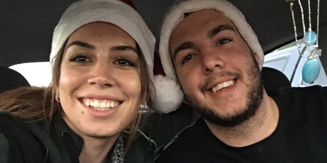 Amanda Hicks and her brother Eric Hicks wear Santa hats.