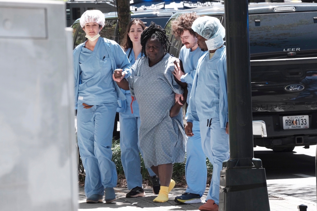 A patient is helped away from the shooting scene.