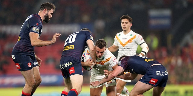 Catalans Dragons is tackled by a St Helens player