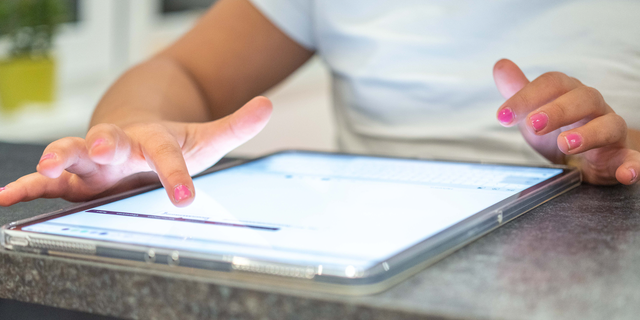 Child typing on iPad