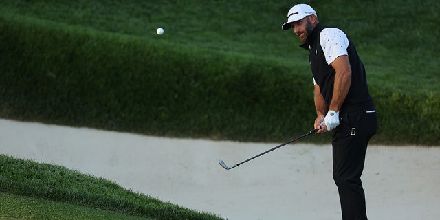 Dustin Johnson chips on the 13th green