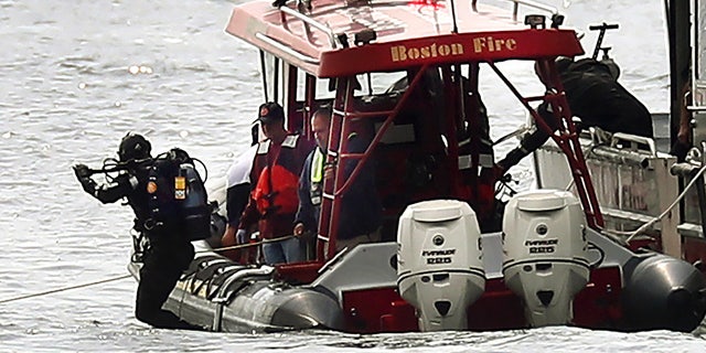 A Boston Fire diver jumps into the water off Castle Island