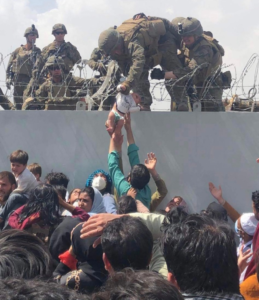Omar Haidari, shows a US Marine grabbing an infant over a fence of barbed wire during an evacuation at Hamid Karzai International Airport in Kabul on August 19, 2021.