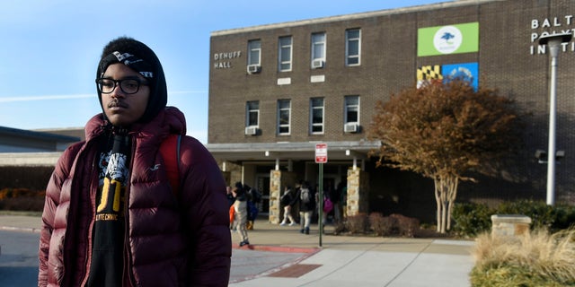 Student stands outside of a Baltimore City high school