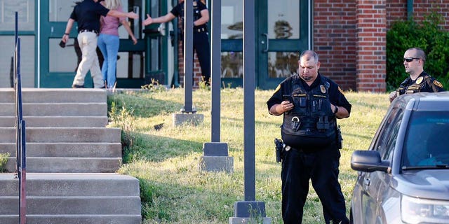 Law enforcement stand outside of Henryetta High School