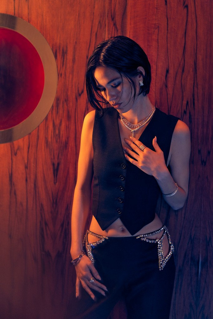 A posed shot of Kelsey Asbille in a cropped waistcoat.