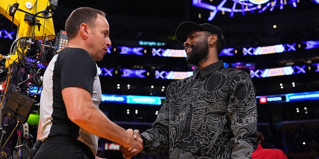 Referee Josh Tiven and Kyrie Irving shake hands