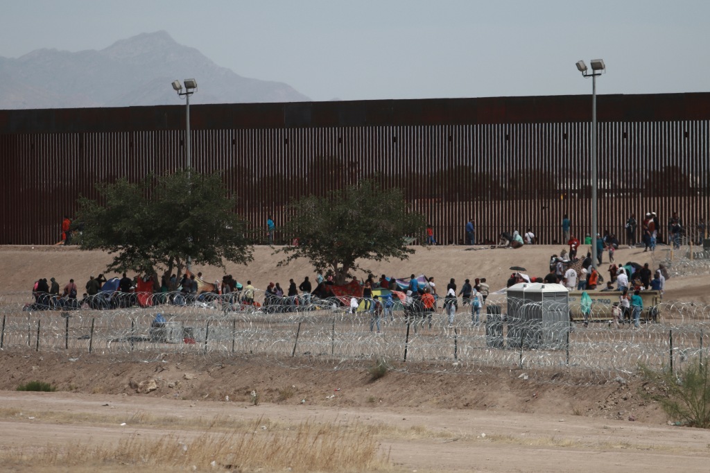 Migrants camp out between a barbed-wire barrier and the border fence between El Paso, Texas and Ciudad Juárez.