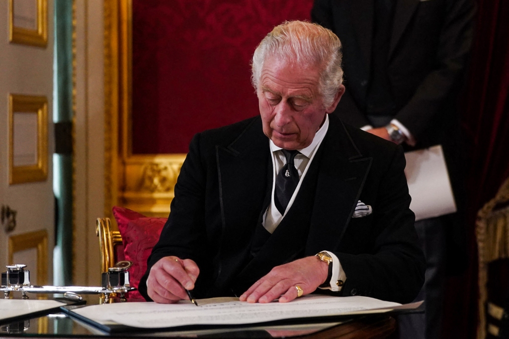 Britain's King Charles III signs an oath to uphold the security of the Church in Scotland, during a meeting of the Accession Council inside St James's Palace in London on September 10, 2022, to proclaim him as the new King. - Britain's Charles III was officially proclaimed King in a ceremony on Saturday, a day after he vowed in his first speech to mourning subjects that he would emulate his "darling mama", Queen Elizabeth II who died on September 8. 