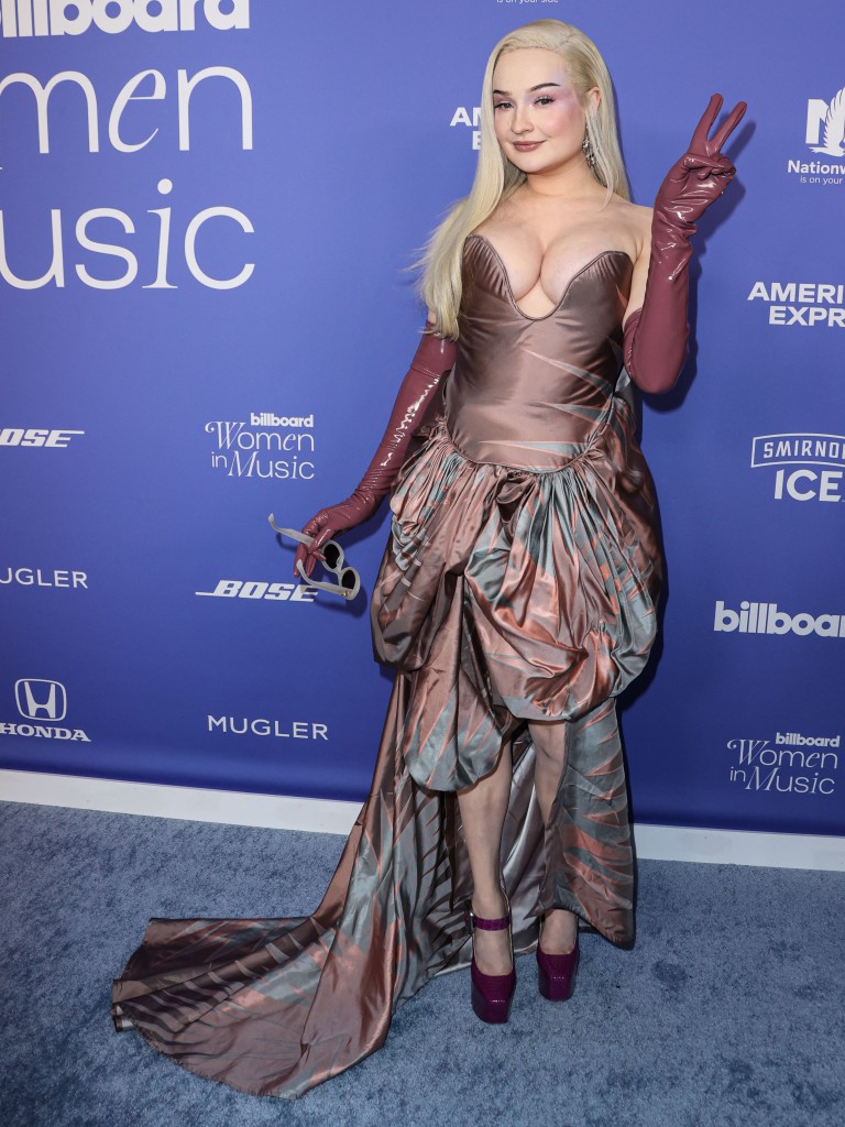 Blonde woman on red carper wearing eveningwear. 