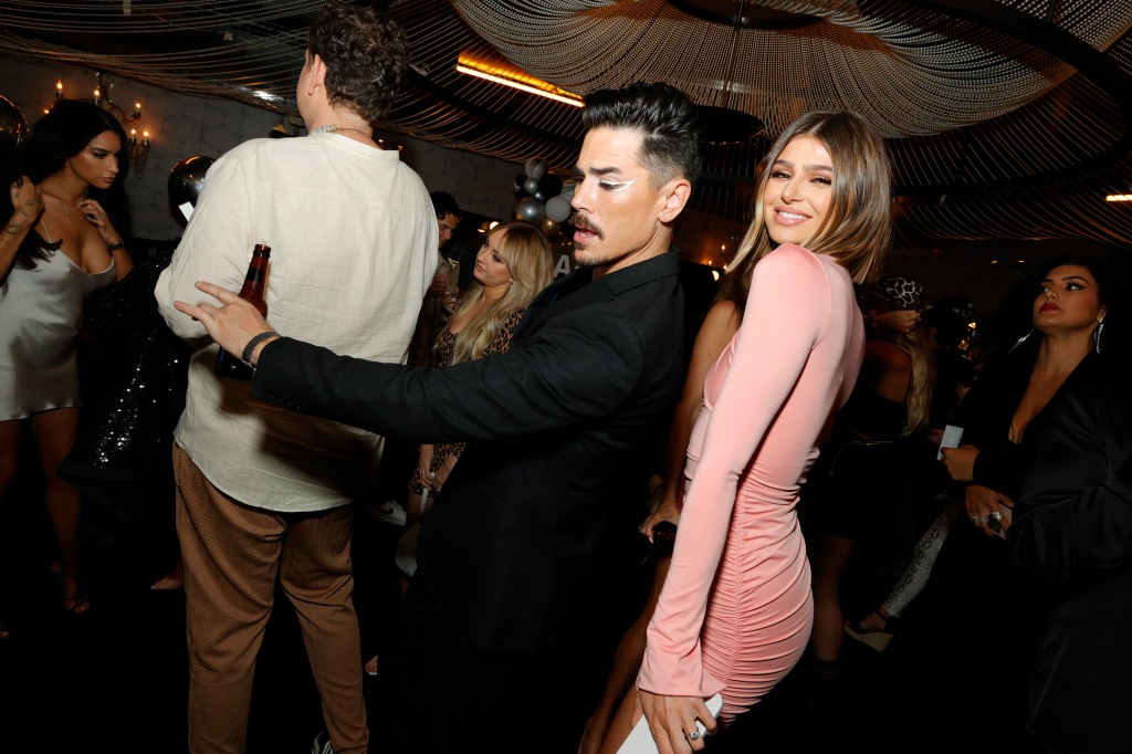 Tom Sandoval and Raquel Leviss dancing close together in a crowded event. 