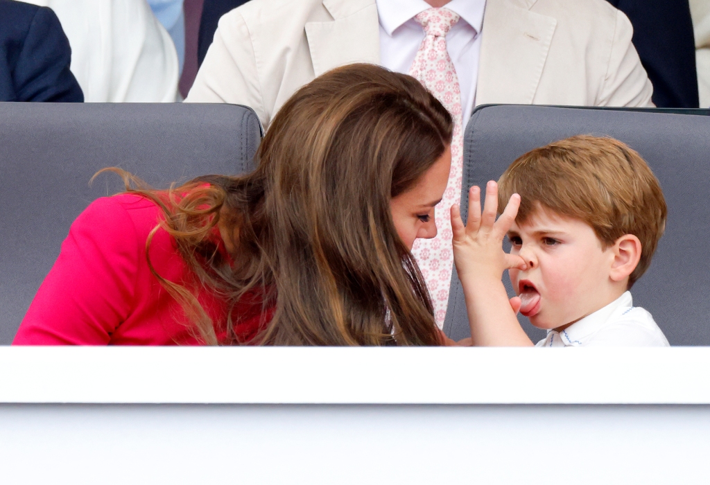 Prince Louis is reprimanded by his mother as he sticks out his tongue and makes a funny face.