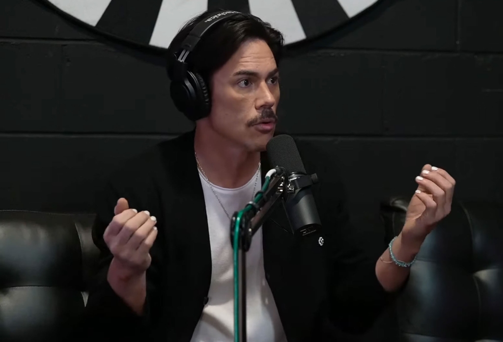 Tom Sandoval with headphones on, talking into a mic. 