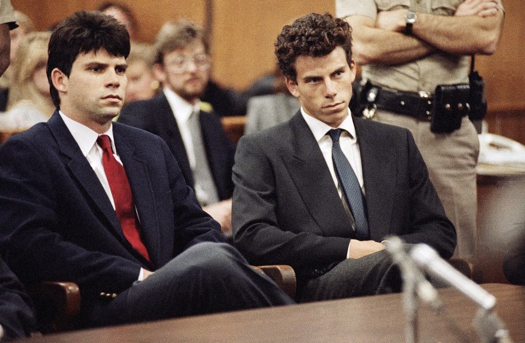 Lyle, left, and Erik Menendez, right, looking serious wearing suits, sitting in court. 
