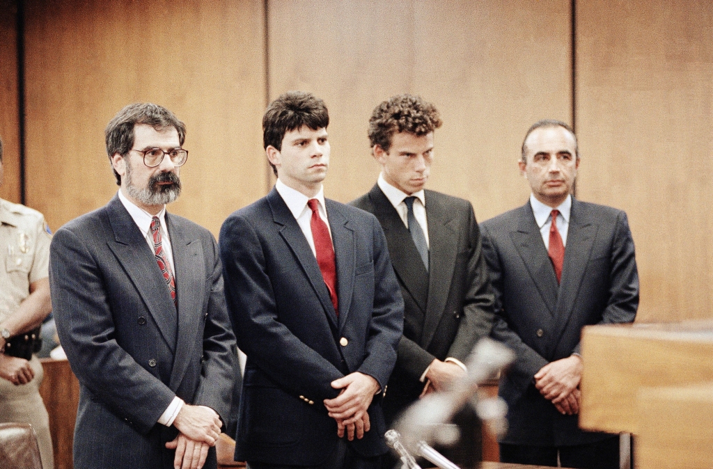 The Menendez brothers wearing suits standing in court. 