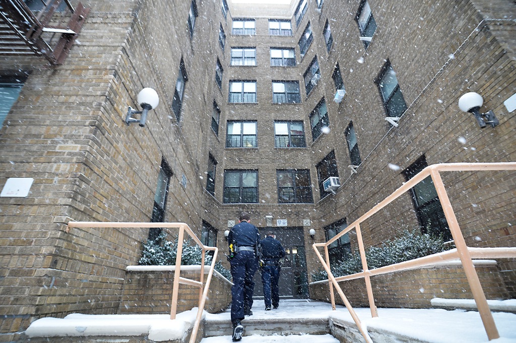 Two police officers walk into the Bronx apartment building where Rosa died.