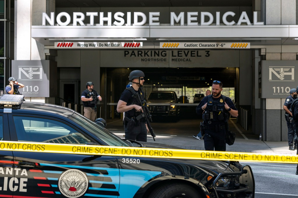 Law enforcement officers stand outside Northside Hospital Midtown medical office building.