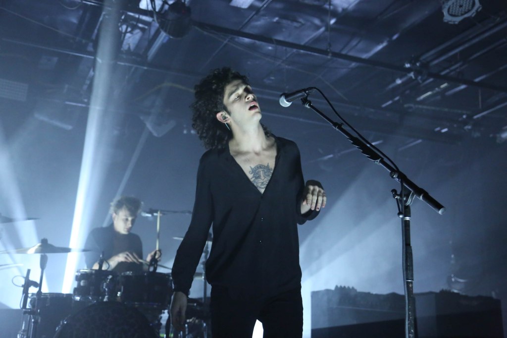 Matty Healy onstage signing. 