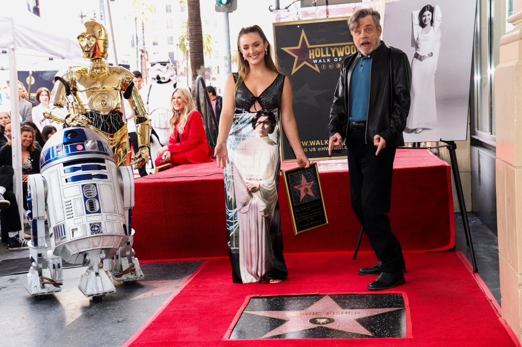 Billie Lourd (left)  and Mark Hamill (right) pose along Star Wars characters C-3PO and R2-D2 next to the star of actor Carrie Fisher during its posthumous unveiling ceremony on the Hollywood Walk of Fame.