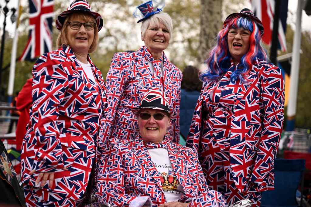 Royal fans dressed with different Union Jack-colored items pose for pictures along the procession route.