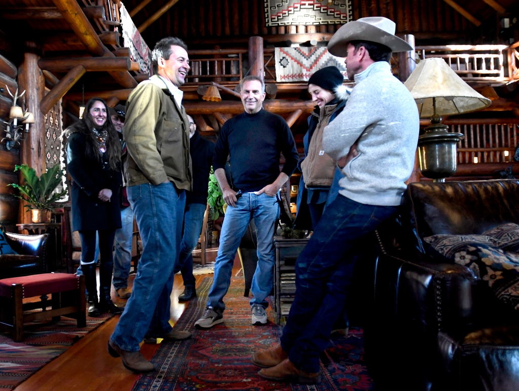 Montana Gov. Steve Bullock, left, with Kevin Costner, production designer Ruth De Jong and Taylor Sheridan, standing in a circle talking. 