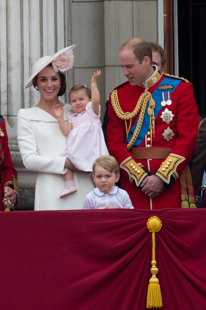 Kate Middleton holds Princess Charlotte as she waves during a flyover in 2016. Also pictured is her father, Prince William, and brother, Prince George.