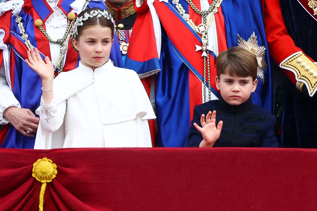 Charlotte and her brother, Prince Louis, wave to the crowds on the balcony of Buckingham Palace after the coronation. 