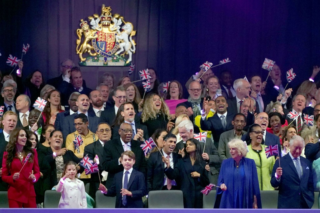 Group of rayals waving flags in royal box.