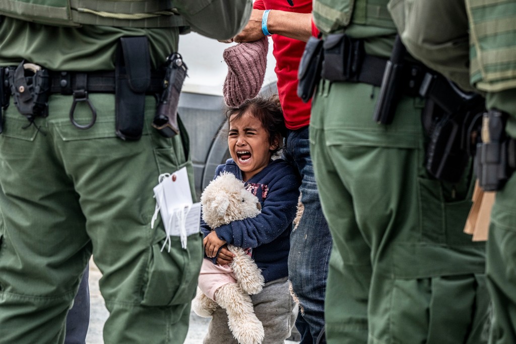 A little girl cries while surrounded by Border Patrol agents