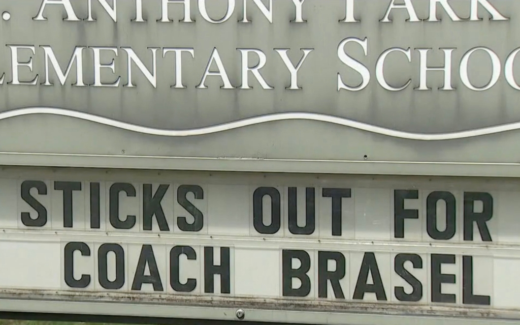 A sign that says "Sticks out for Coach Brasel"