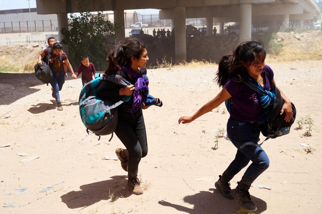 Migrants flee as Mexican police officers approach near the  Ysleta-Zaragoza bridge in El Paso, Texas on Saturday, May 13, 2023. 