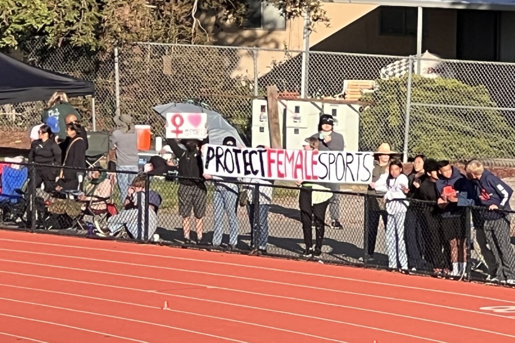 People were seen at the race with posters that opposed having trans athletes in female sports.