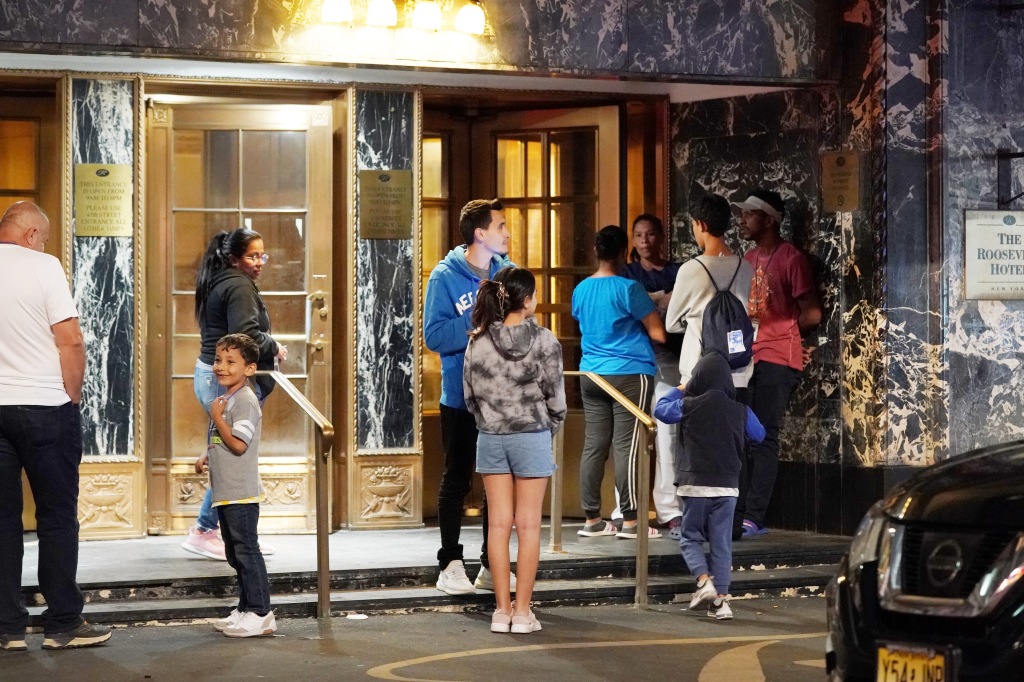 Migrants gather outside the Roosevelt Hotel, which is a resource center for asylum seekers.